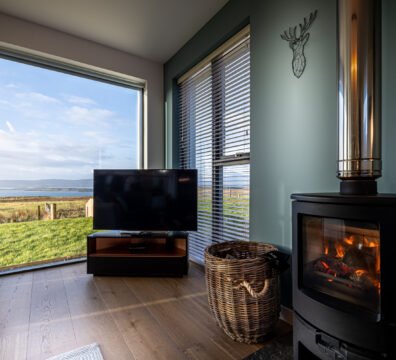 Fireplace and television area at Long View, with expansive views from floor to ceiling windows