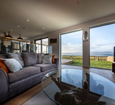 The living room at Long View, featuring a designer wood and glass coffee table and a beautiful view
