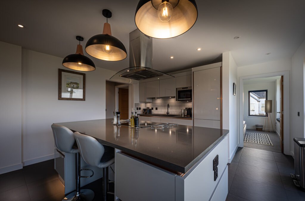 The Long View kitchen island with designer lighting hanging above
