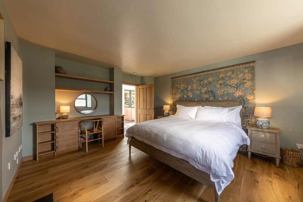 Tern House superking bedroom, featuring oak wood, dusky blue walls and a large tapestry