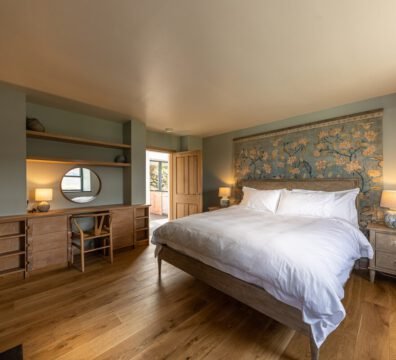Tern House superking bedroom, featuring oak wood, dusky blue walls and a large tapestry