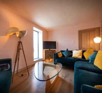 The warm, Scandinavian style living room with tasteful wood and glass furnishings at Tern House, a Skye and Shore property