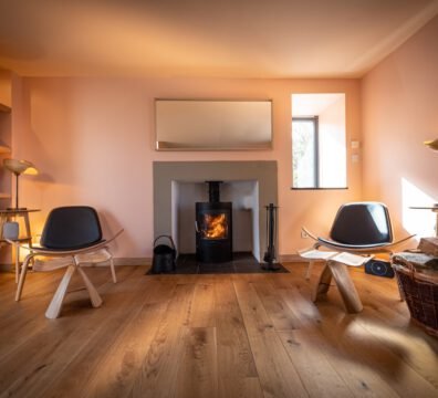 A cosy fireplace inside a warm and stylish living room at Tern House, a Skye and Shore property